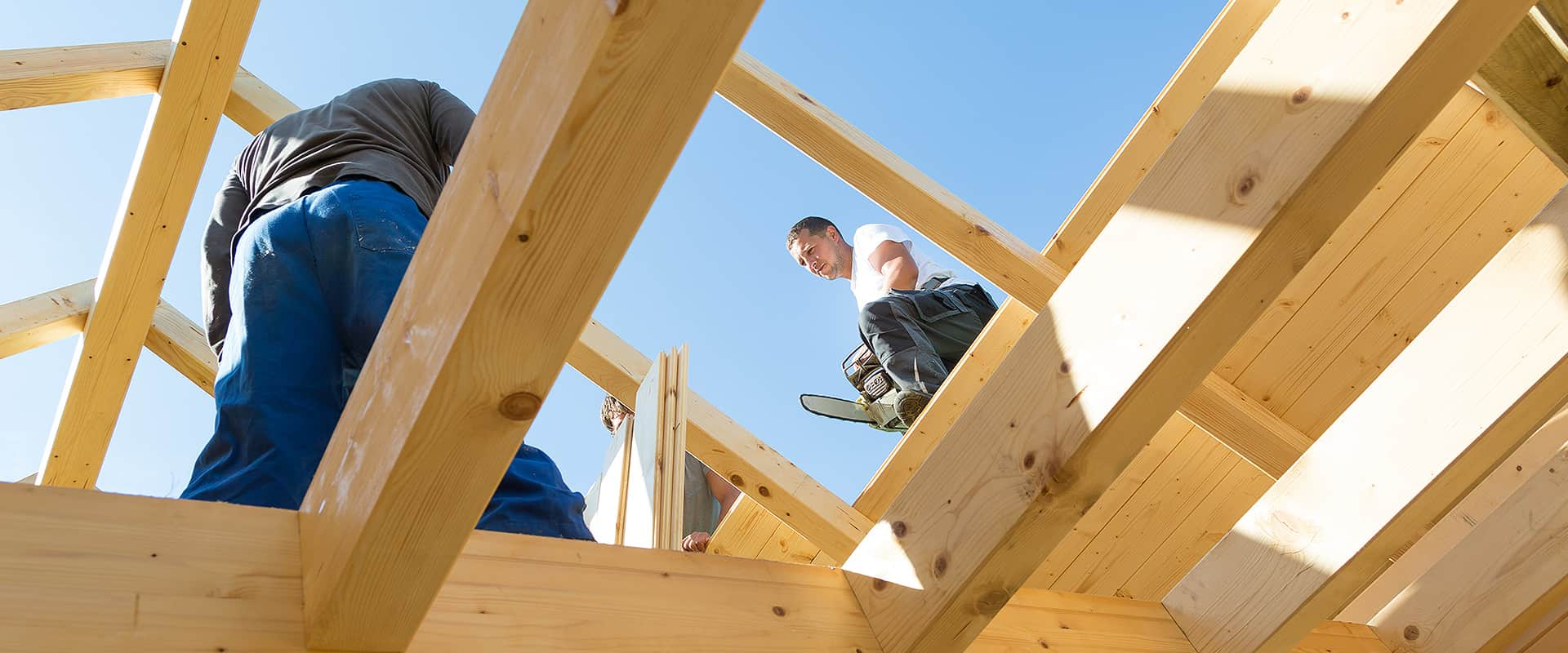 Zwei Handwerker arbeiten am Gerüst eines Dachstuhls